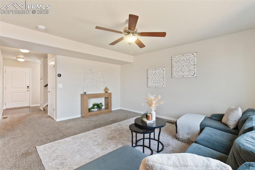 Image 5 of 28: Carpeted living room featuring baseboards and a ceiling fan