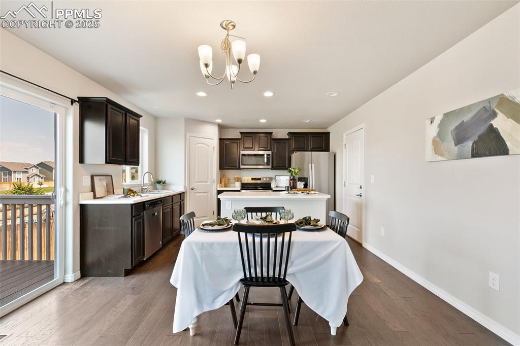 Image 9 of 28: Dining area featuring dark wood finished floors, recessed lighting, and a c
