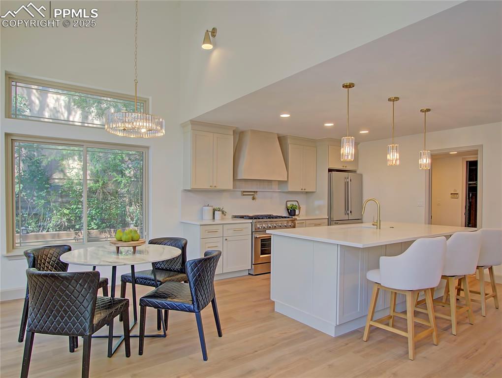 Image 15 of 50: Kitchen featuring premium appliances, a chandelier, light countertops, cust