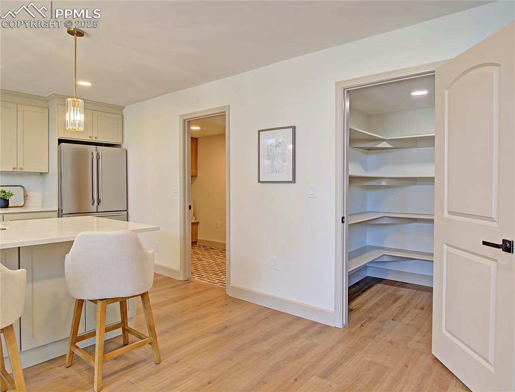 Image 23 of 50: Kitchen with high quality fridge, light wood-type flooring, a breakfast bar