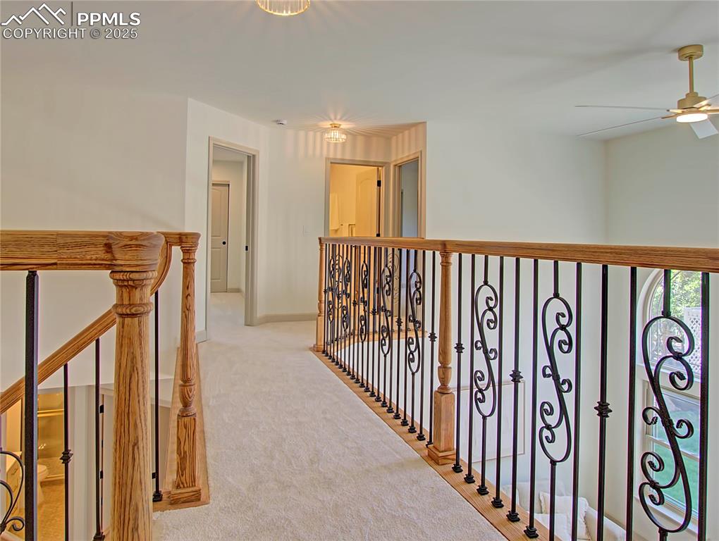 Image 29 of 50: Hallway with light colored carpet and an upstairs landing