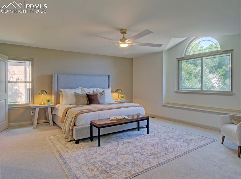 Image 31 of 50: Primary Bedroom featuring carpet floors, vaulted ceiling, and a ceiling fan