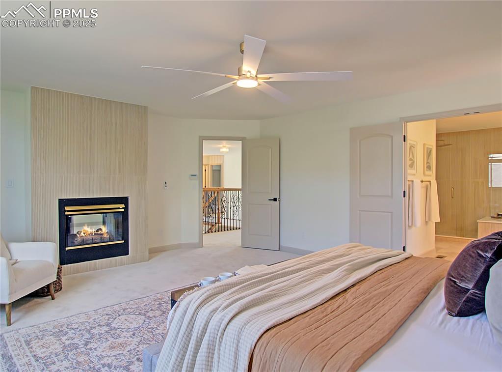 Image 32 of 50: Primary Bedroom with carpet floors, a multi sided fireplace, ensuite bathro