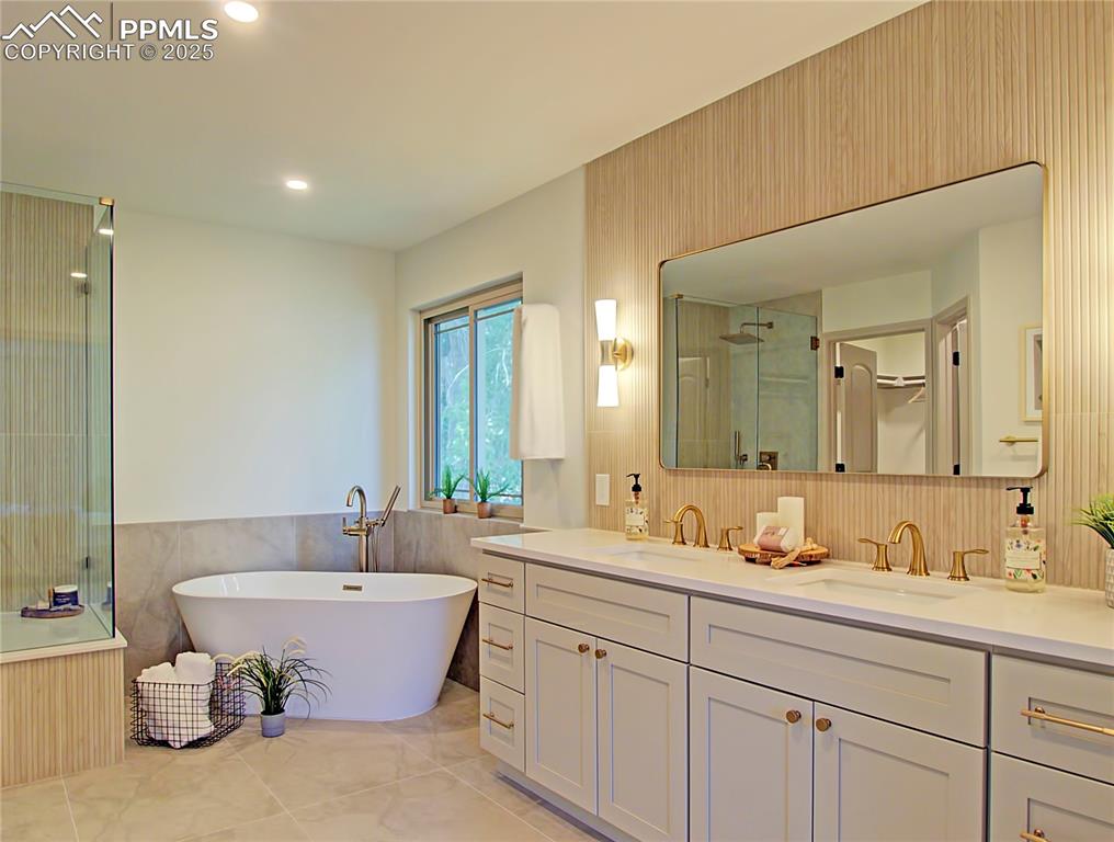 Image 33 of 50: Primary bathroom with double vanity, a soaking tub, a shower with shower do