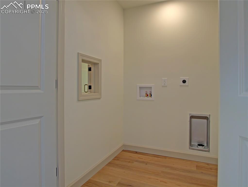 Image 37 of 50: Laundry room upstairs with electric dryer hookup, light wood-type flooring,