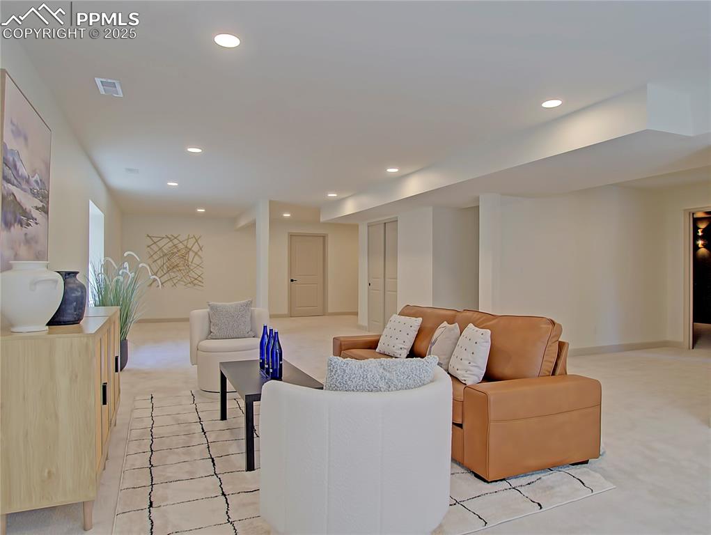 Image 43 of 50: Basement living room with light colored carpet and recessed lighting