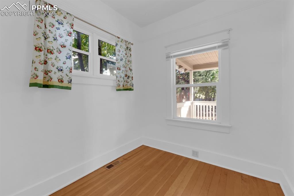 Image 10 of 28: Spare room featuring baseboards and hardwood / wood-style flooring