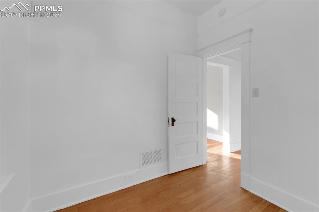 Image 12 of 28: Unfurnished room with wood-type flooring and baseboards