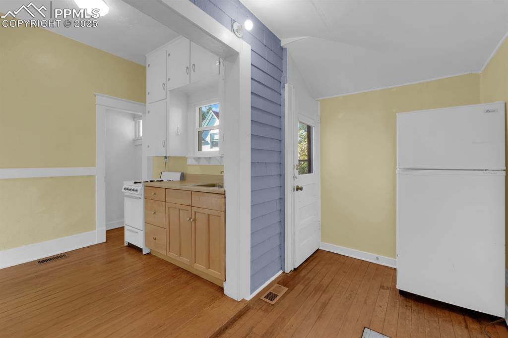 Image 20 of 28: Kitchen with white appliances, light countertops, light wood-style flooring