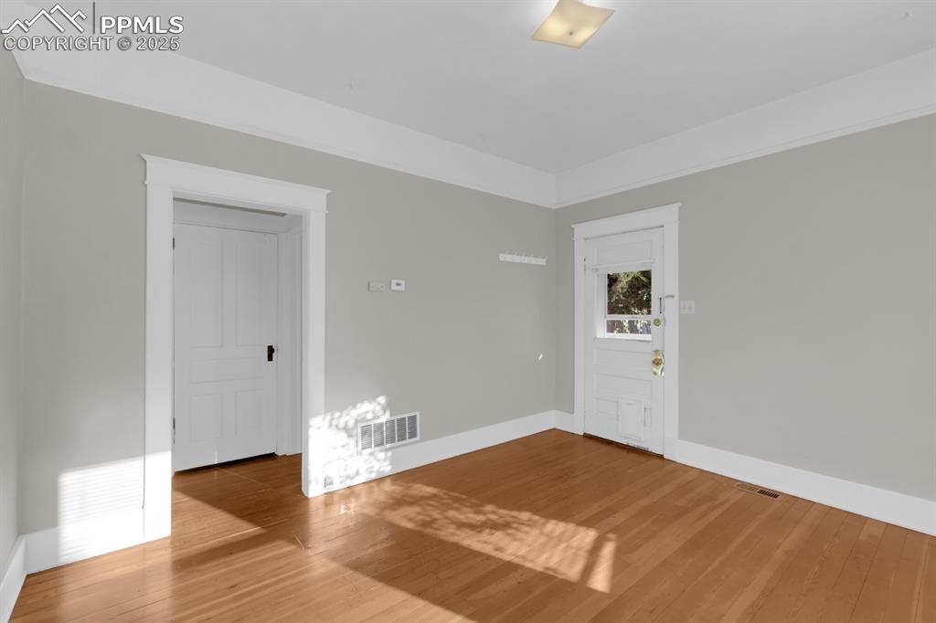 Image 9 of 28: Empty room with light wood finished floors