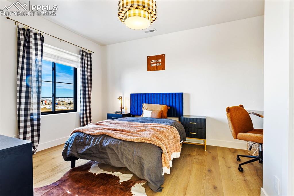Image 17 of 49: Bedroom featuring wood finished floors and an office area