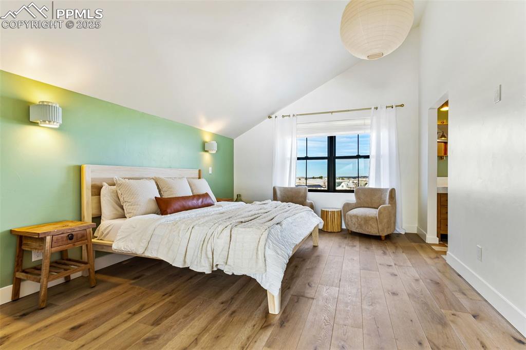 Image 21 of 49: Bedroom with light wood-type flooring and high vaulted ceiling