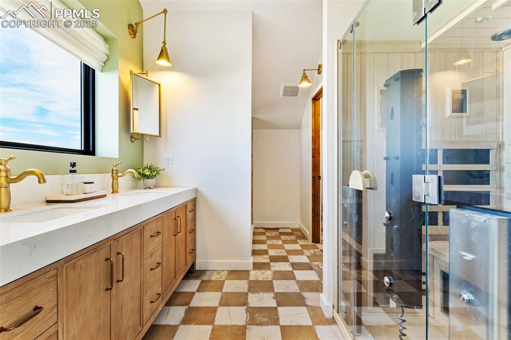Image 26 of 49: Bathroom with double vanity, a shower stall, and a sauna