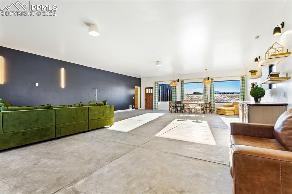 Image 31 of 49: Living room featuring finished concrete floors