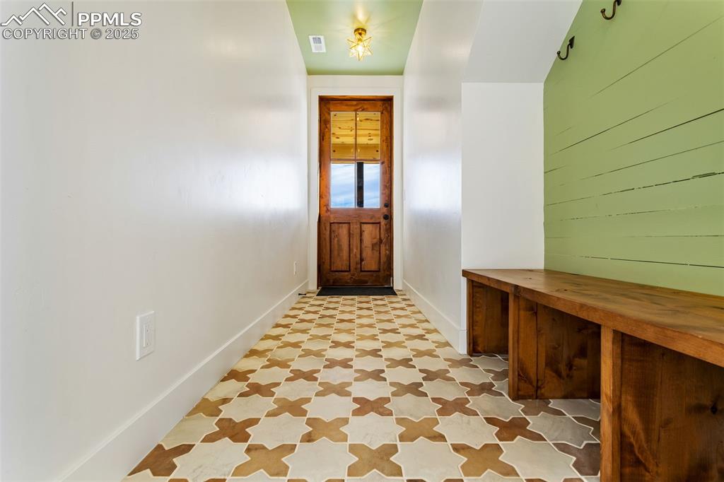 Image 39 of 49: Doorway with tile patterned floors and baseboards