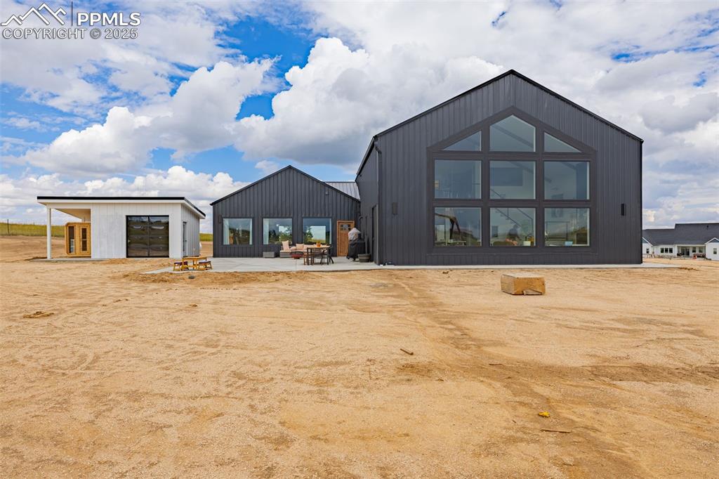 Image 48 of 49: Back of property with a patio, a garage, and an outdoor structure