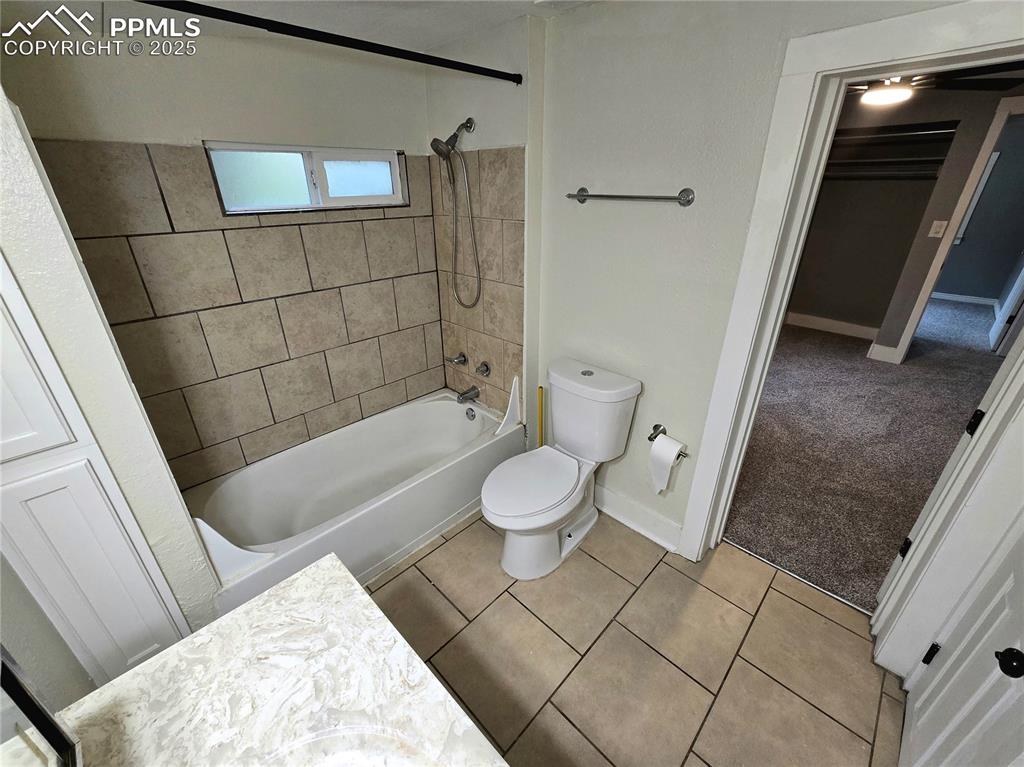 Image 10 of 22: Bathroom featuring toilet, shower / tub combination, tile patterned floorin