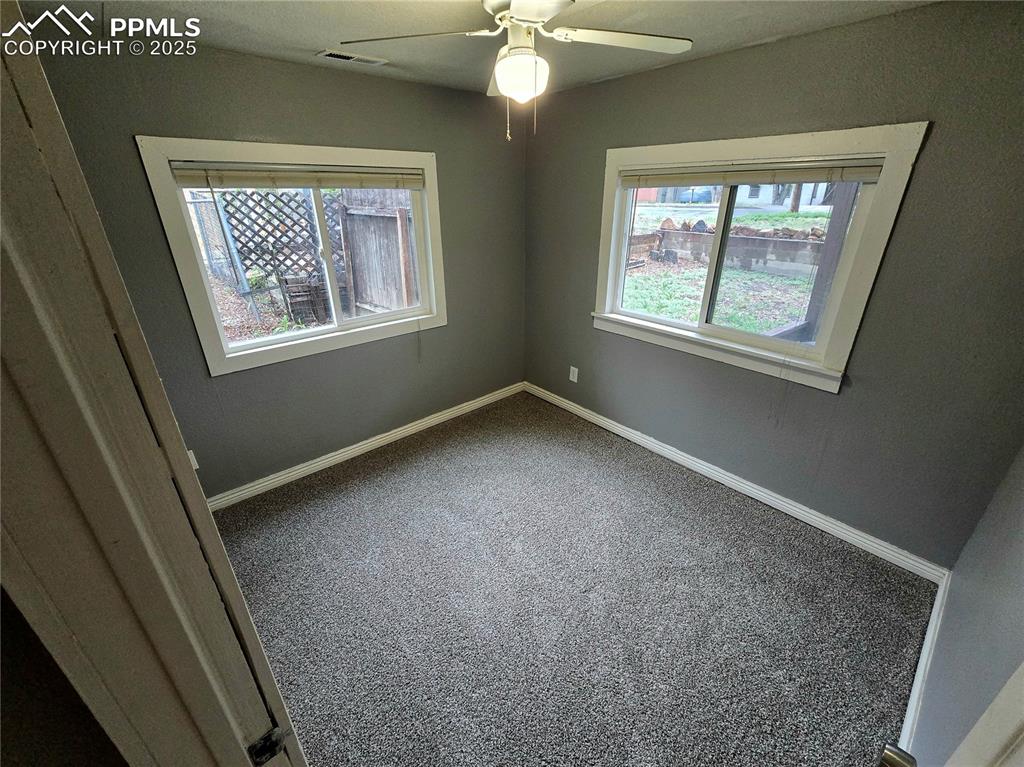Image 11 of 22: Carpeted spare room with baseboards and ceiling fan