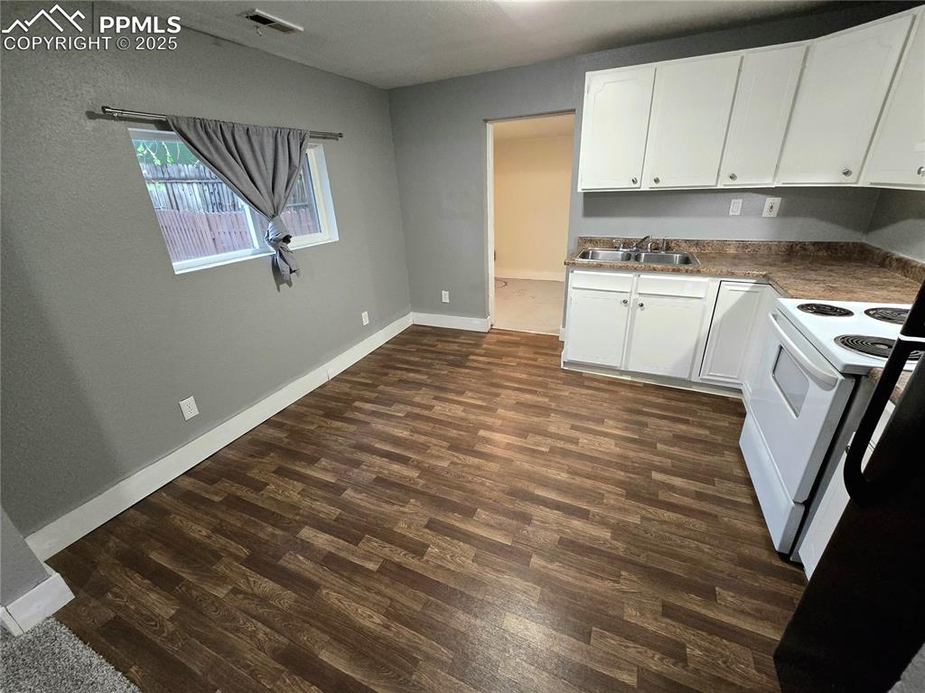 Image 3 of 22: Kitchen featuring a sink, electric range, dark wood-style flooring, white c
