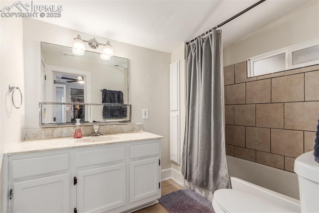 Image 9 of 22: Full bathroom featuring shower / tub combo, vanity, a textured ceiling, and