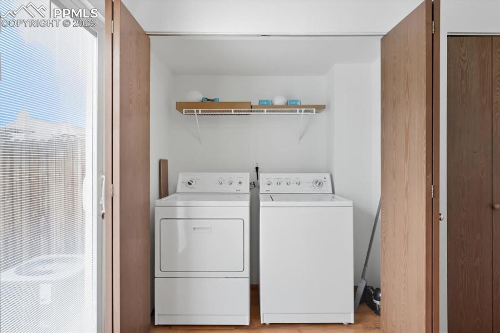 Image 13 of 34: Laundry room featuring washer and clothes dryer and light wood-style floors