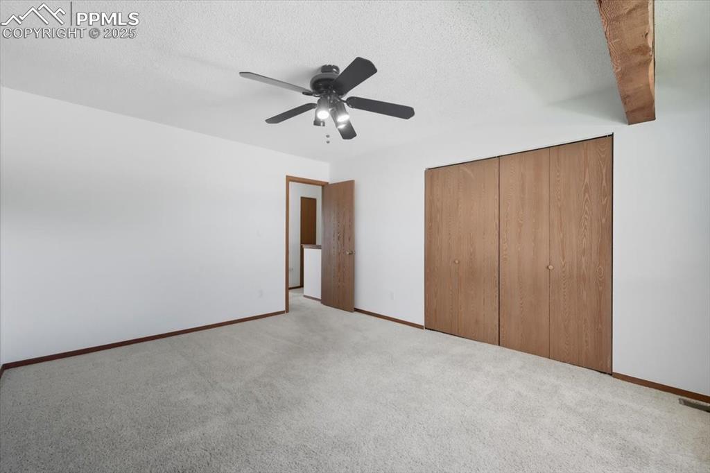 Image 20 of 34: Unfurnished bedroom featuring a closet, carpet flooring, a ceiling fan, and