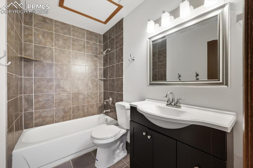 Image 21 of 34: Full bathroom with shower / bath combination, tile patterned floors, and va