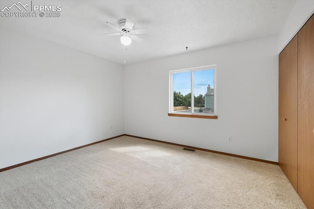Image 22 of 34: Unfurnished bedroom with a closet, carpet floors, ceiling fan, and a textur