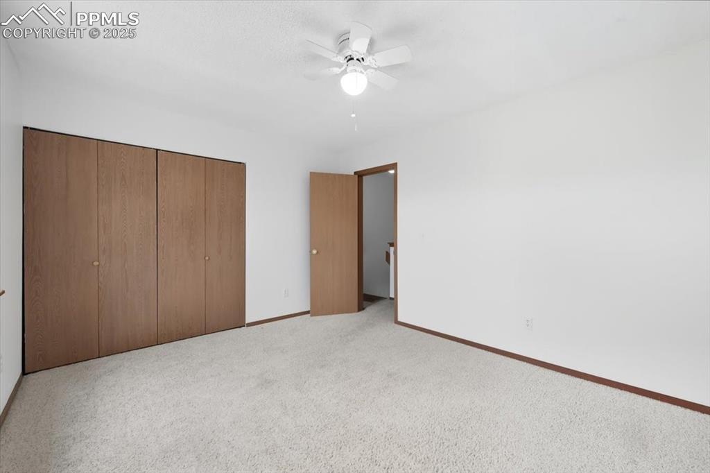 Image 23 of 34: Unfurnished bedroom featuring a closet, carpet flooring, and ceiling fan