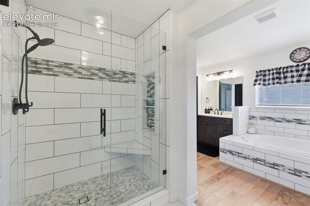 Image 21 of 50: oversized shower with custom tile accents and built-ins