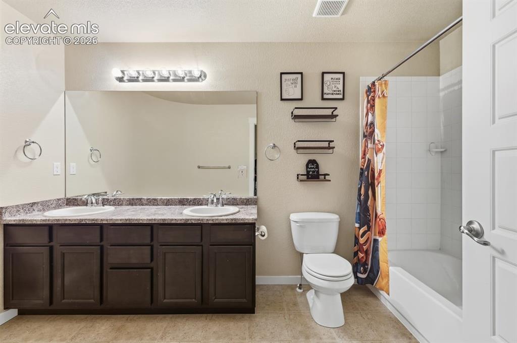 Image 29 of 50: upstairs hall bath with dual sinks