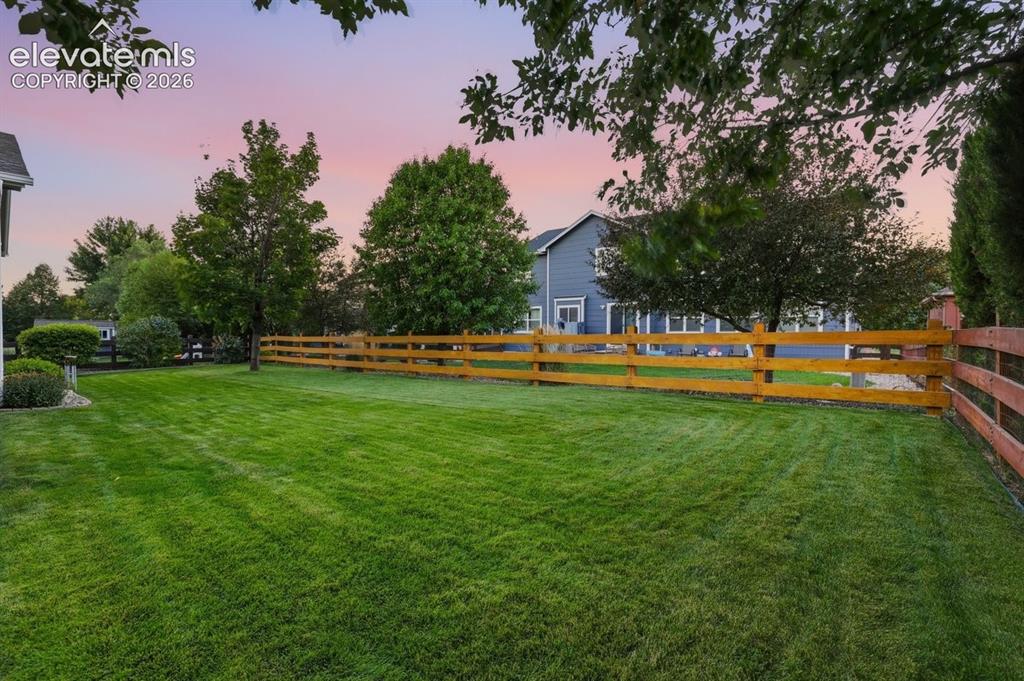 Image 39 of 50: large fenced in yard with lush green grass