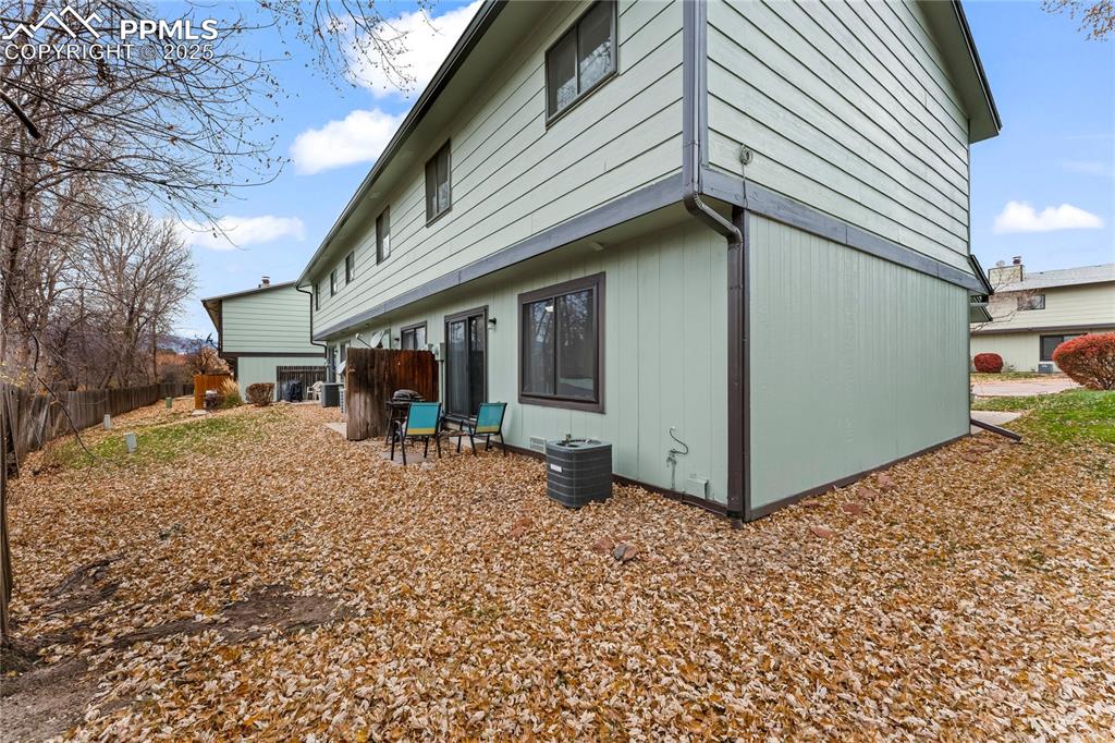 Image 21 of 21: End unit, yard, mature trees, back patio