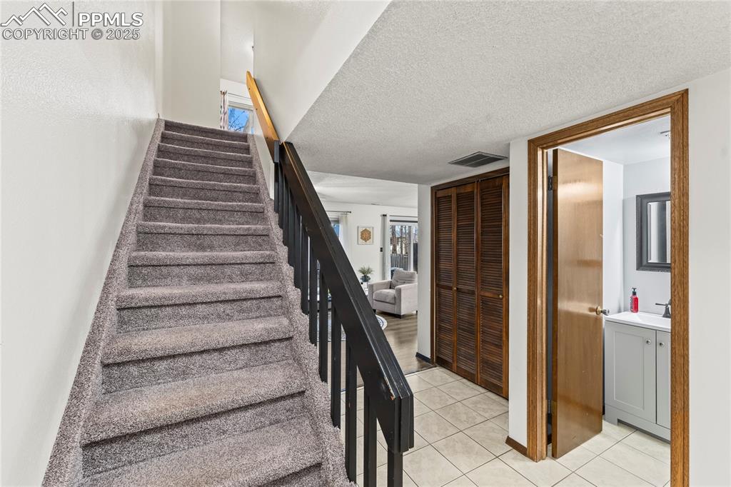 Image 9 of 21: Front entry view 1/2 bath and stair case leading into livingroom