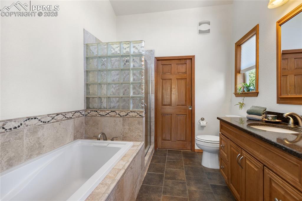 Image 29 of 50: Primary bedroom bath is extra roomy with tub plus shower, vaulted ceilings