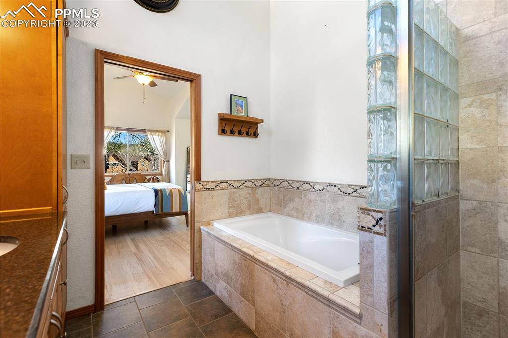 Image 30 of 50: Primary bedroom bath is extra roomy with tub plus shower, vaulted ceilings