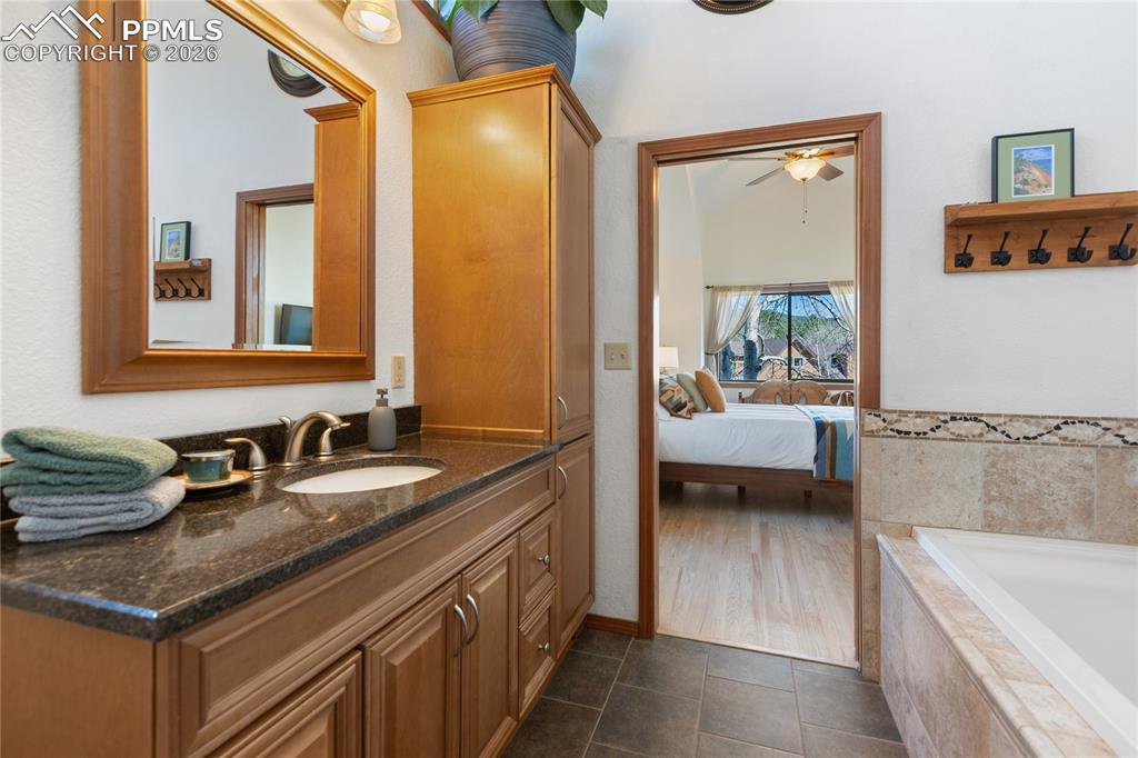 Image 31 of 50: Primary bedroom bath is extra roomy with tub plus shower, vaulted ceilings