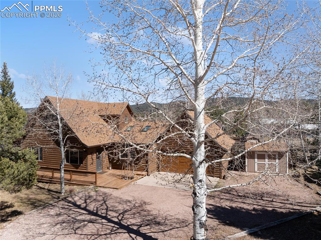 Image 46 of 50: Classic Woodland Park curb appeal, log siding, aspens and pines. 2 car atta