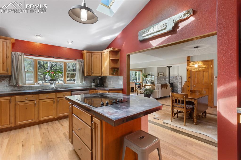 Image 8 of 50: Kitchen is updated! Stainless steel appliances, concrete counters, vaulted
