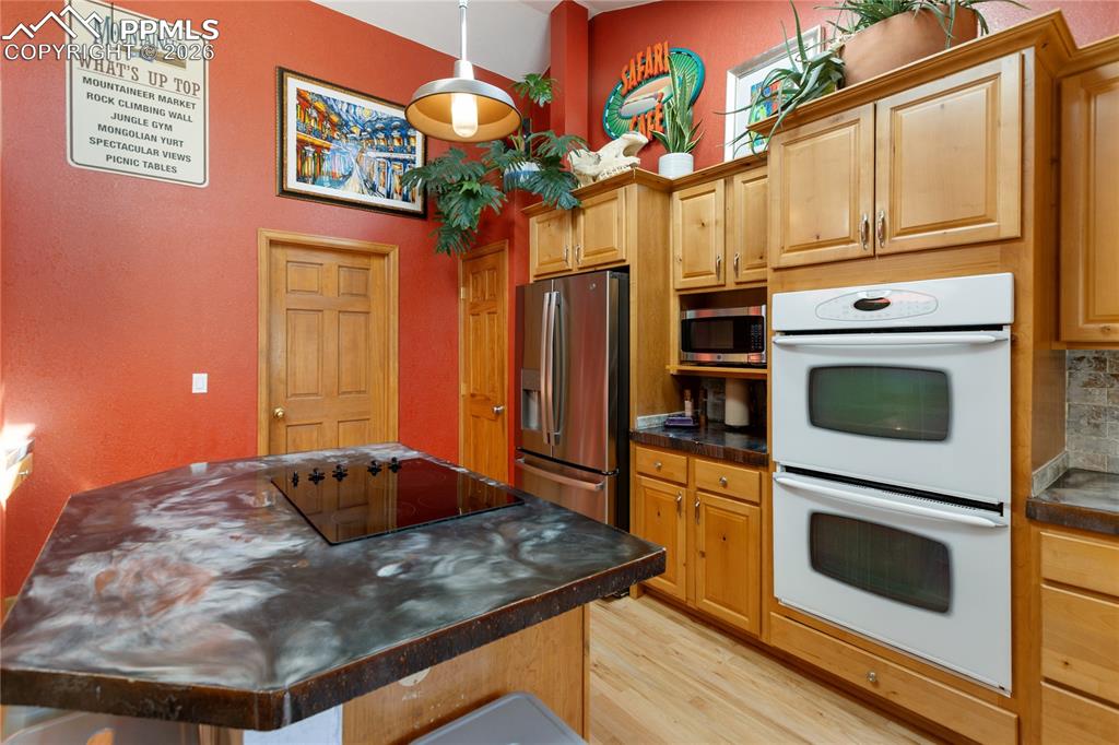 Image 9 of 50: Kitchen is updated! Stainless steel appliances, concrete counters, vaulted