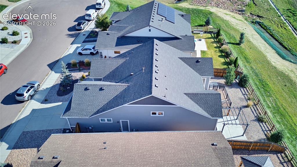 Image 11 of 50: Aerial view of a residential property featuring a gray exterior, asphalt sh