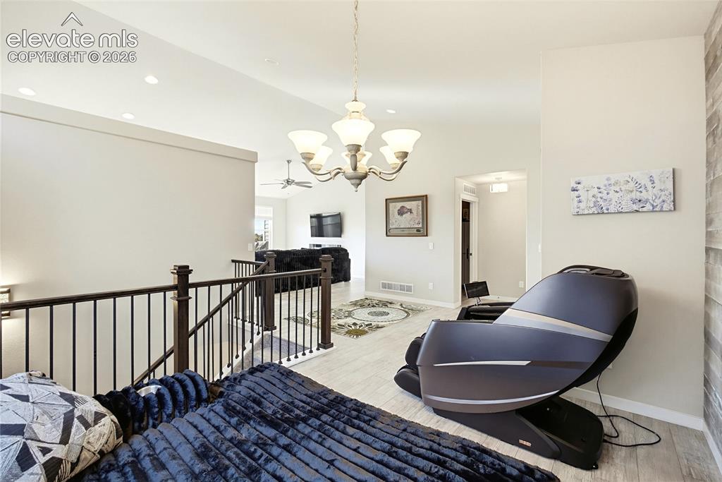 Image 15 of 50: Open-concept interior featuring light wood-finish flooring, a wrought-iron 
