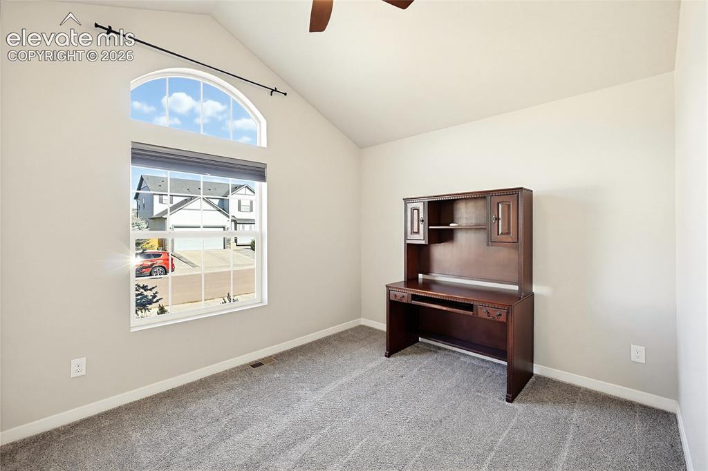 Image 18 of 50: Vaulted ceiling with a central fan, arched window, and wall-to-wall carpeti