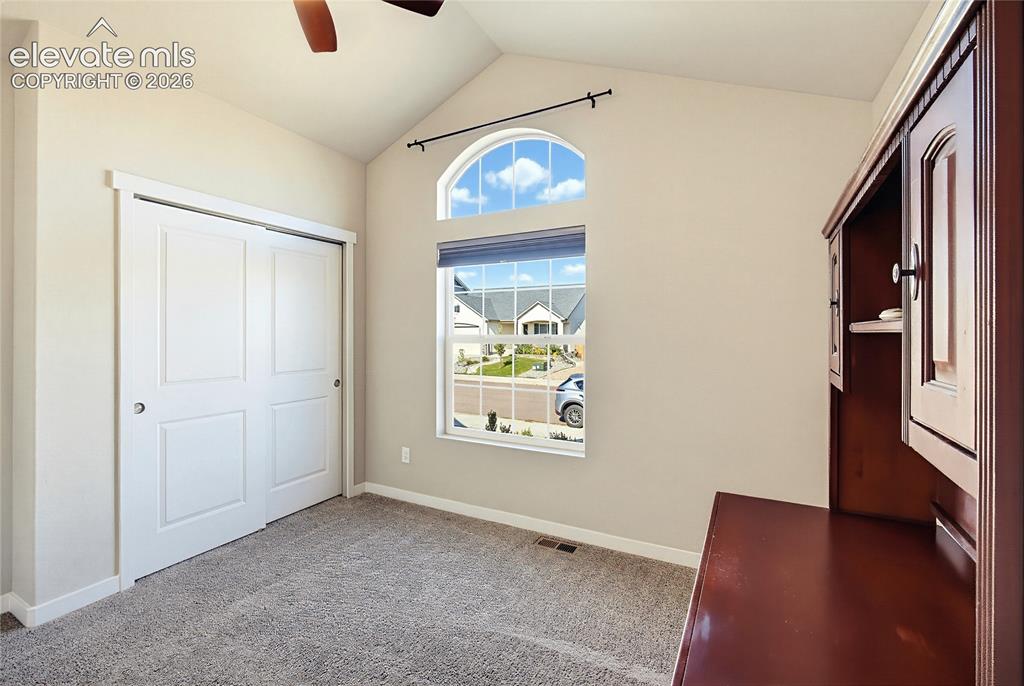 Image 19 of 50: Vaulted ceilings featuring an arched window, neutral wall palette, carpetin