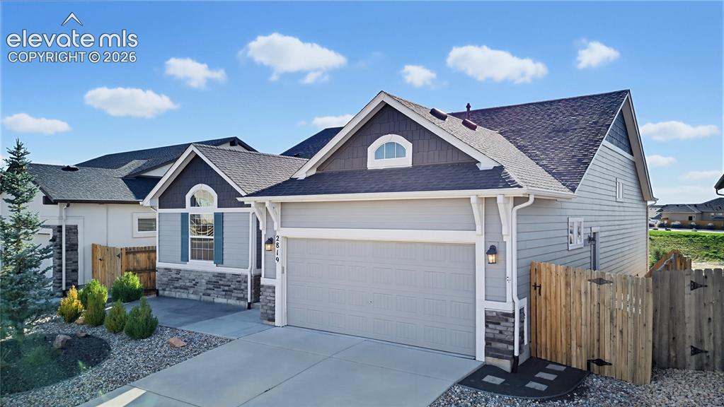 Image 2 of 50: Exterior featuring horizontal siding with stone veneer accents, multi-gable