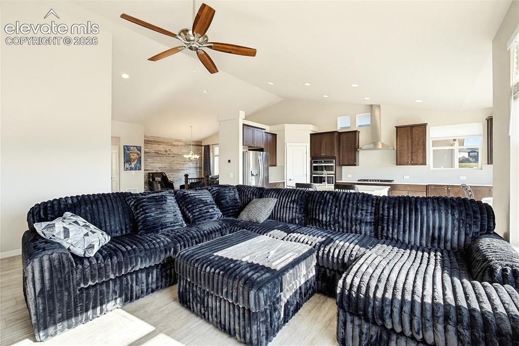 Image 23 of 50: Vaulted ceilings, recessed lighting, wood-finish flooring, and a kitchen fe