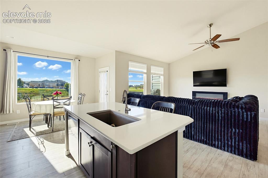 Image 24 of 50: Kitchen island featuring a quartz countertop and integrated sink, vaulted c