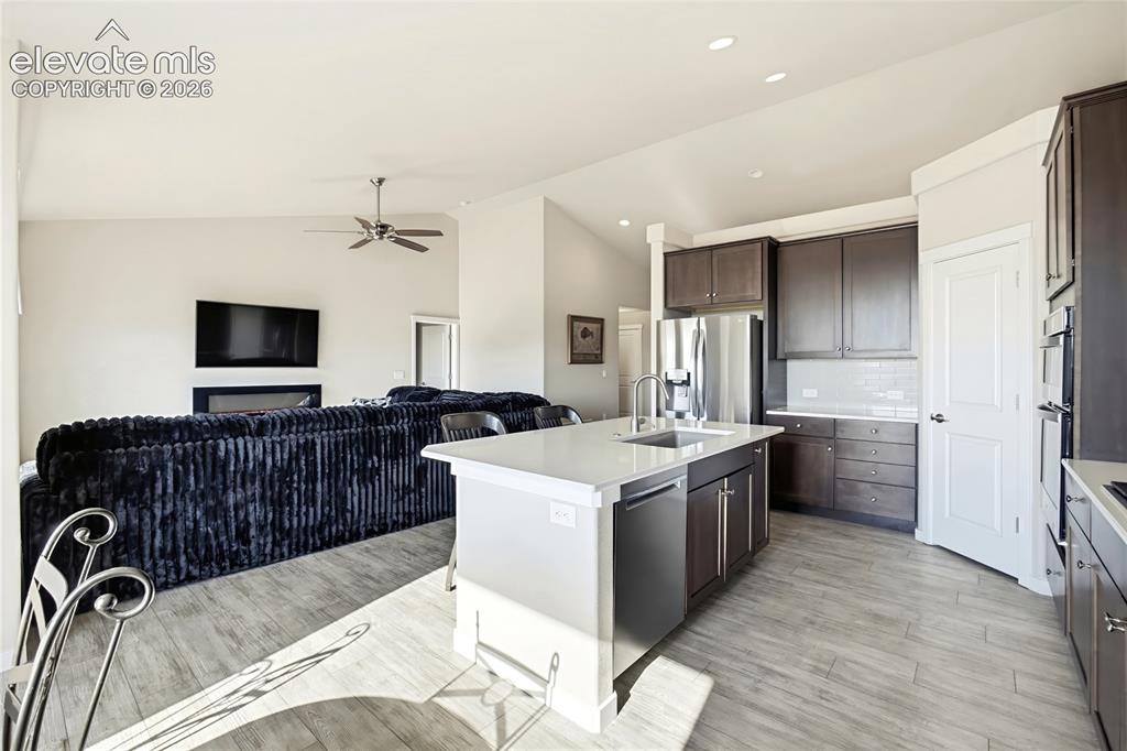 Image 25 of 50: Open-concept kitchen featuring an island with a quartz countertop, stainles