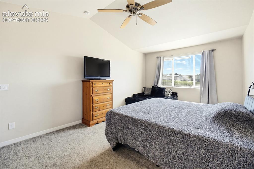 Image 34 of 50: Vaulted ceiling featuring a central multi-blade ceiling fan, wall-to-wall c