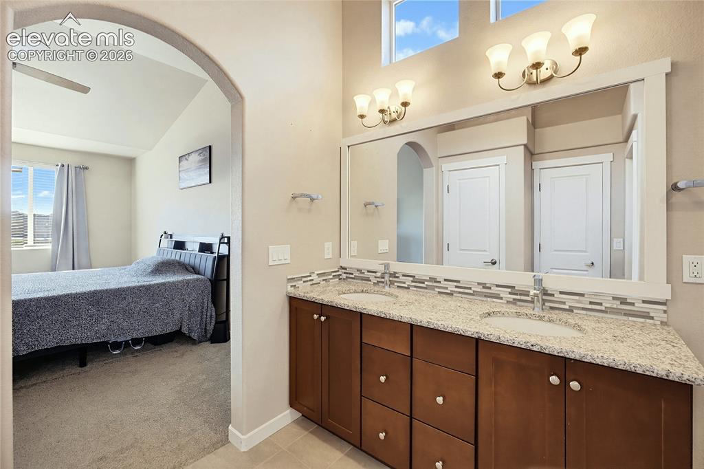 Image 36 of 50: Double vanity with stone countertop, mosaic tile backsplash, framed wall mi